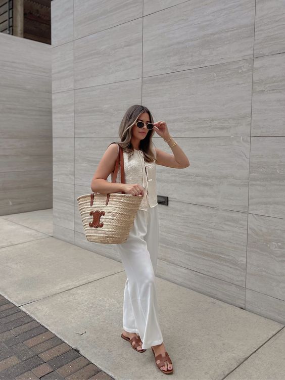 Cream vest and wide-leg trousers paired with a LOEWE straw bag